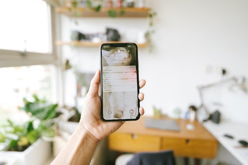 Włączony iphone z powiadomieniami trzymany w salonie